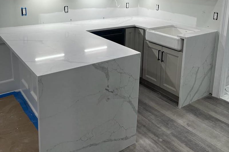 Natural quartzite kitchen worktops with waterfall edge in a bright kitchen